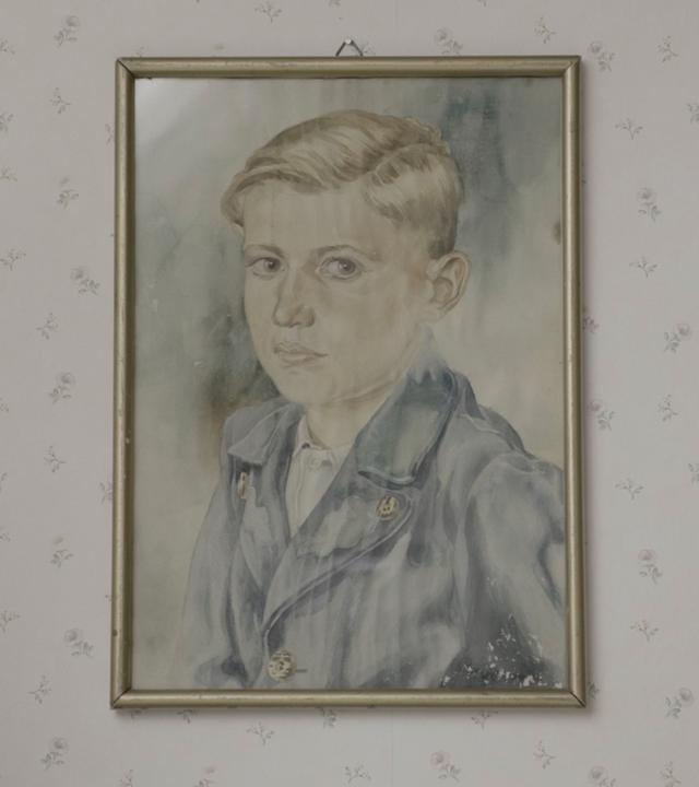 Ein Gemälde von einem Jungen, das an der Wand hängt.