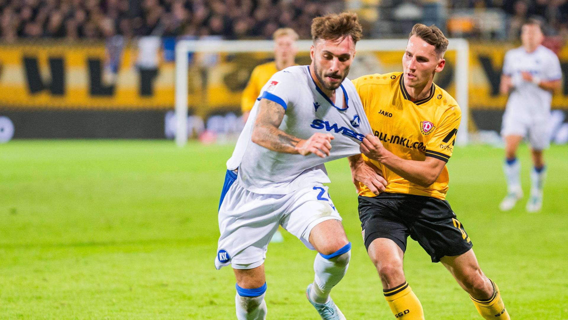 Fabian Schleusener (Karlsruher SC) und Konrad Faber (Dynamo Dresden) kämpfen.