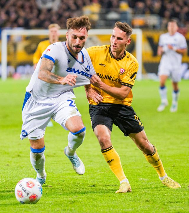 Fabian Schleusener (Karlsruher SC) und Konrad Faber (Dynamo Dresden) kämpfen.