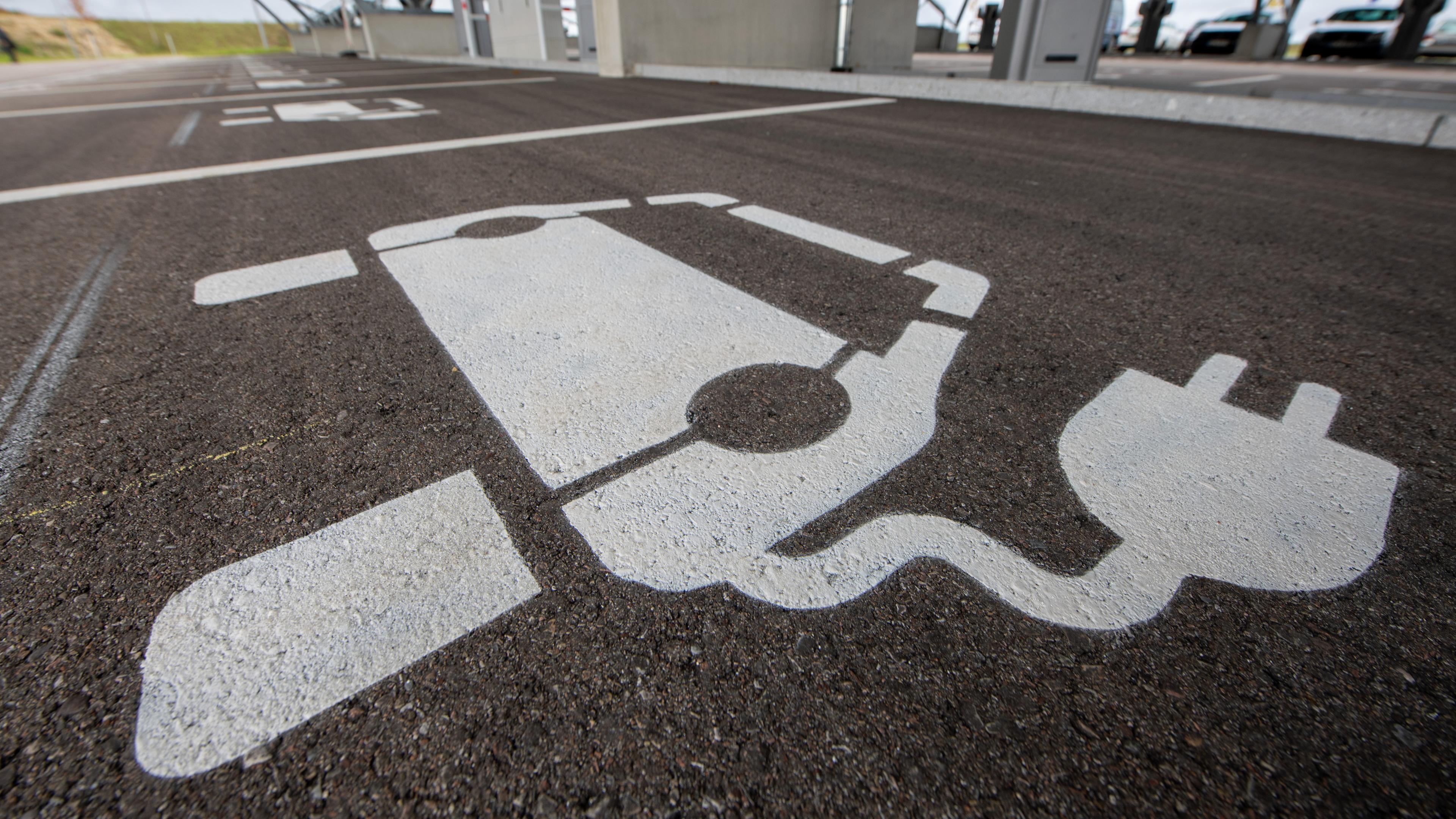 Eine Reihe von Parkplätzen für E-Autos, welche jeweils piktografisch mit einem Auto mit Stromstecker gekennzeichnet sind.
