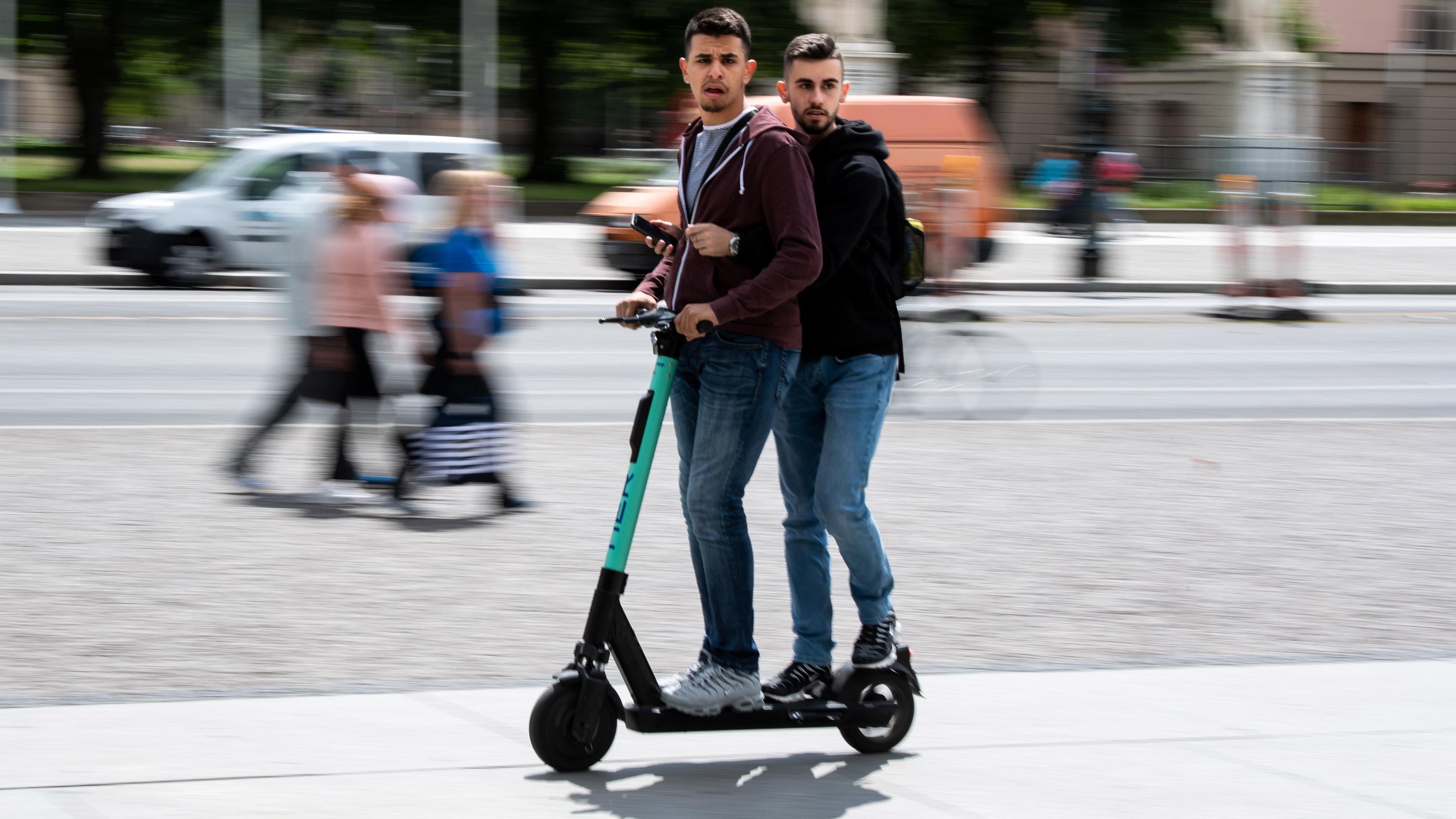 Zwei Männer auf einem E-Scooter