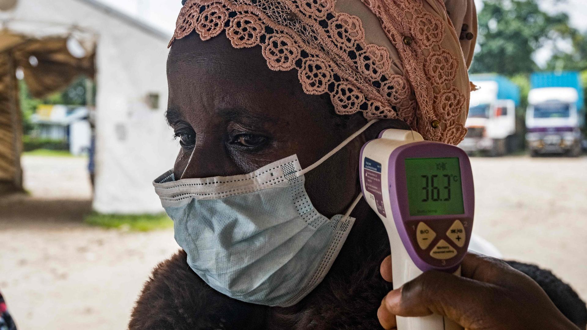 Ein Grenzgesundheitsbeamter am Grenzübergang Busunga zwischen Uganda und der Demokratischen Republik Kongo misst am 18. Mai 2026 in Bundibugyo die Temperatur eines Reisenden mithilfe eines kontaktlosen Infrarotthermometers.