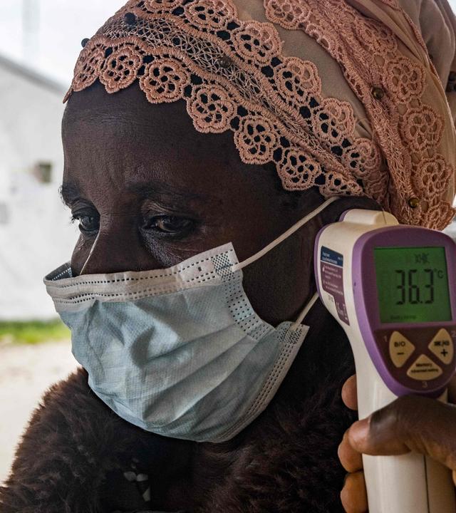 Ein Grenzgesundheitsbeamter am Grenzübergang Busunga zwischen Uganda und der Demokratischen Republik Kongo misst am 18. Mai 2026 in Bundibugyo die Temperatur eines Reisenden mithilfe eines kontaktlosen Infrarotthermometers.