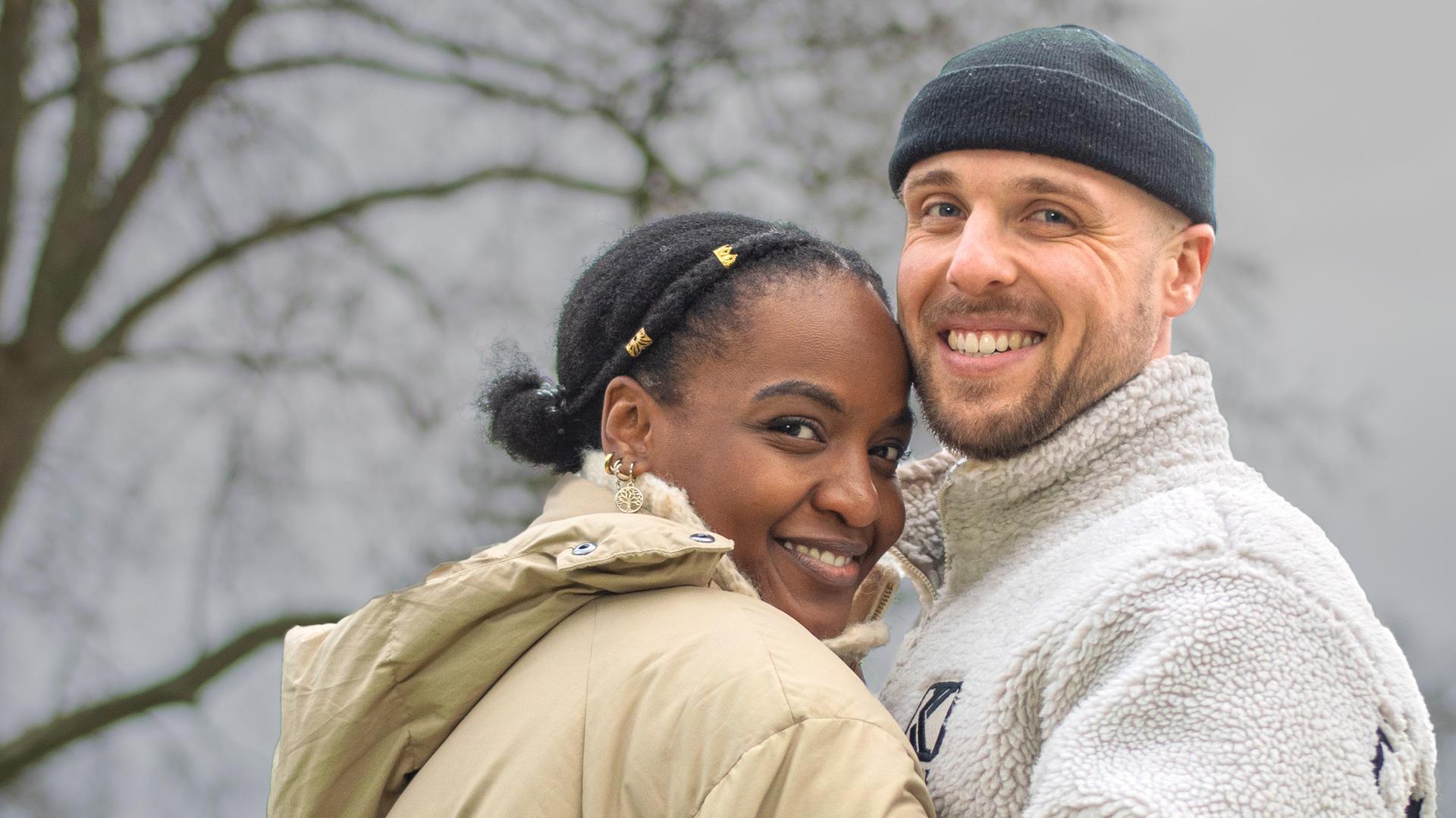 Ein Pärchen vor Bäumen.