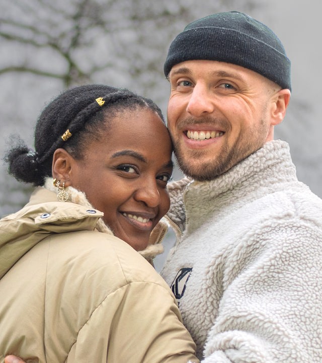 Ein Pärchen vor Bäumen.