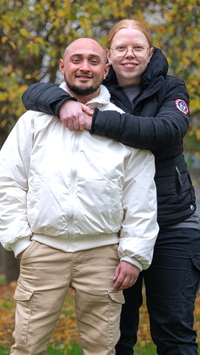 Ein Pärchen steht auf einer Wiese.