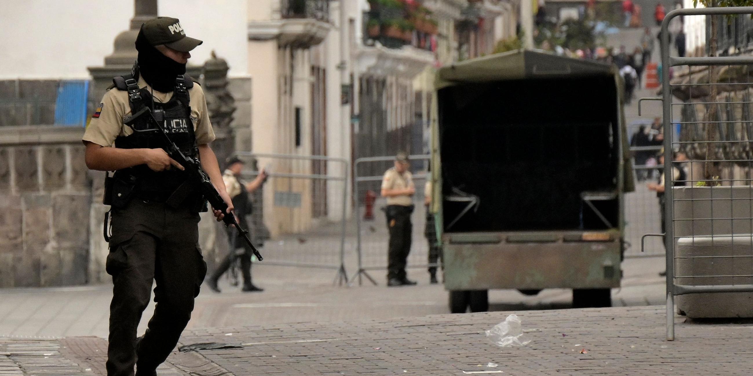 EIn bewaffneter Polizist steht auf einer Straße im Zentrum.