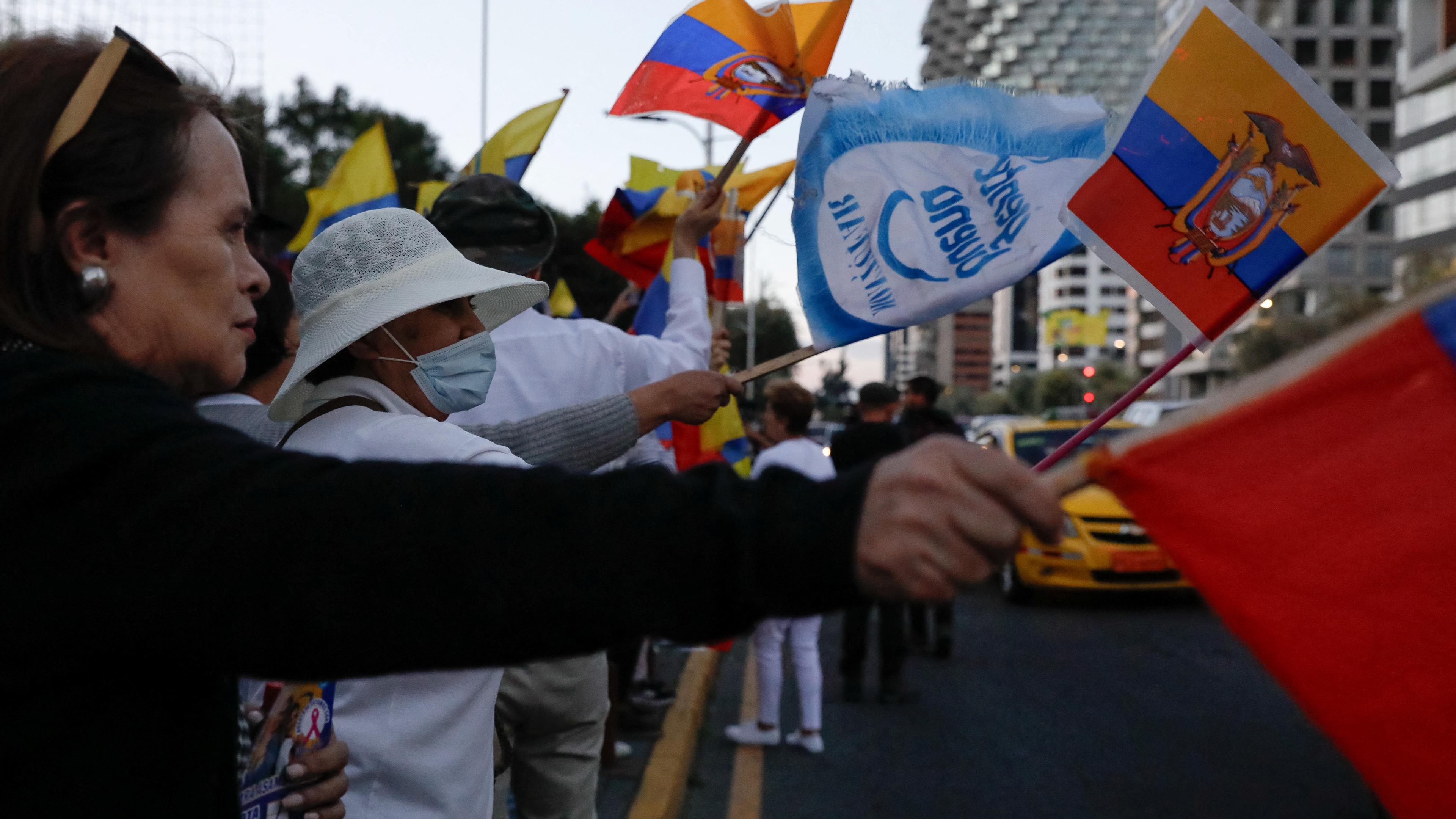 Fahnen schwenkende Menschen protestieren während einer Demonstration nach der Ermordung des ecuadorianischen Präsidentschaftskandidaten Fernando Villavicencio.