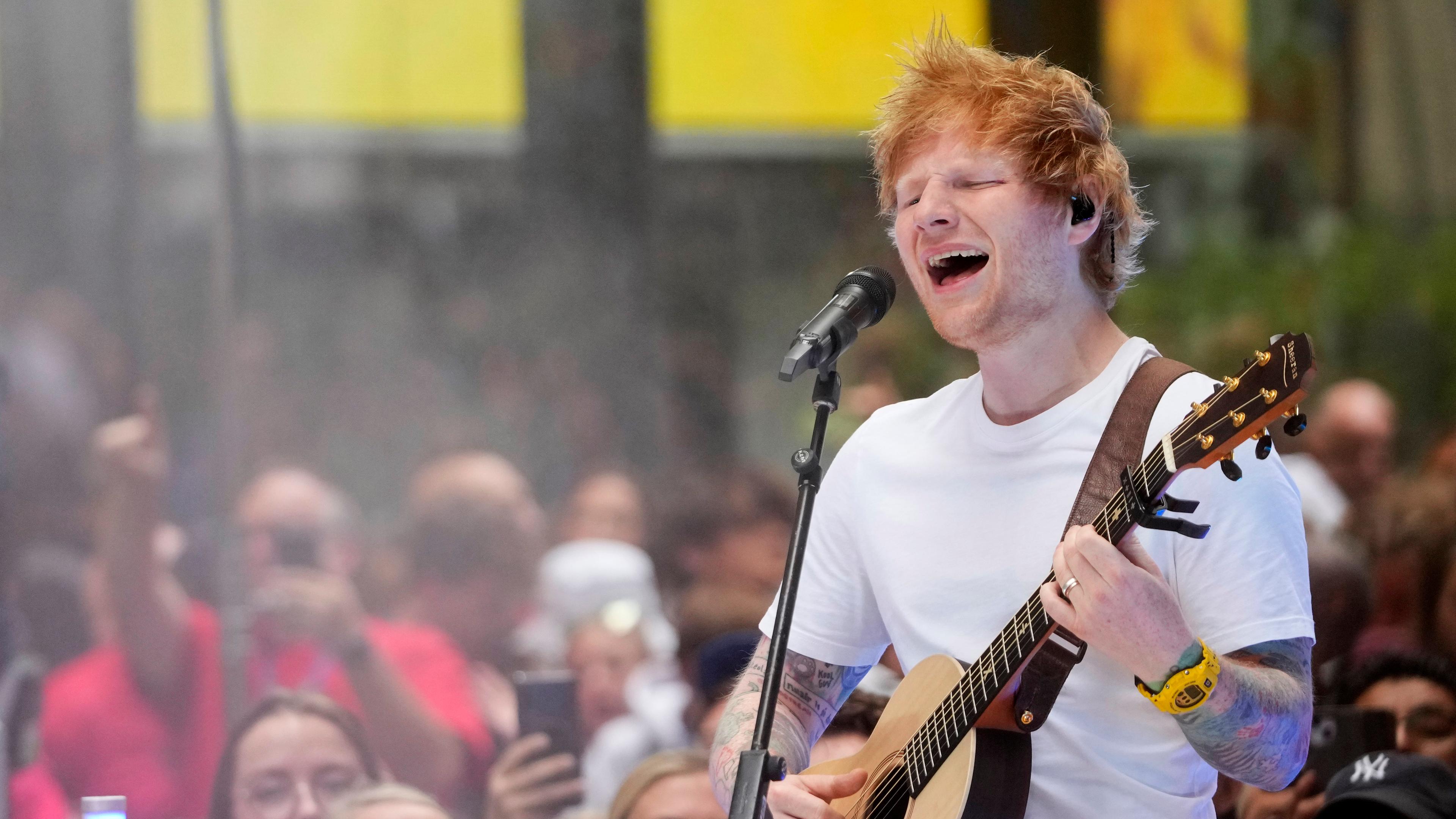 Sänger Ed Sheeran mit Gitarre singt auf einer Bühne