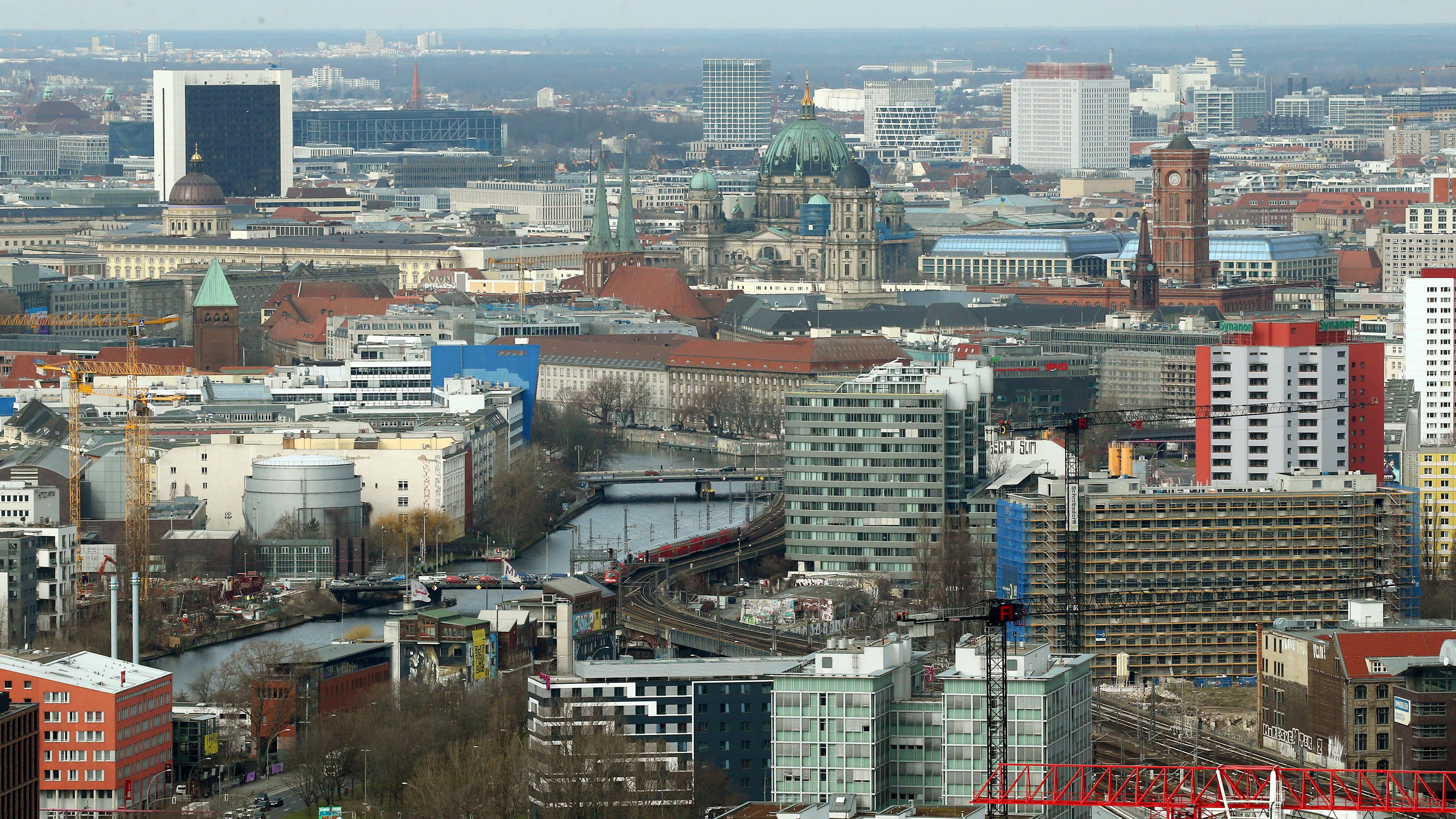 Berlin: Blick aus dem 35. Stockwerk des EDGE East Side Berlin über die Dächer in Richtung Mitte mit dem Roten Rathaus (r) und dem Berliner Dom (M).