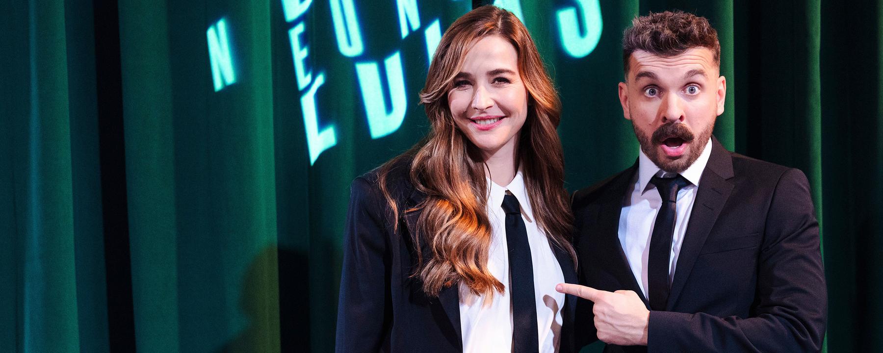 Moderator Edin Hasanovic posiert im Anzug in der Premiere seiner ZDFneo-Show "Edins Neo Night" mit der Moderatorin und Schauspielerin Katrin Bauerfeind, ebenfalls in einem eleganten Anzug.