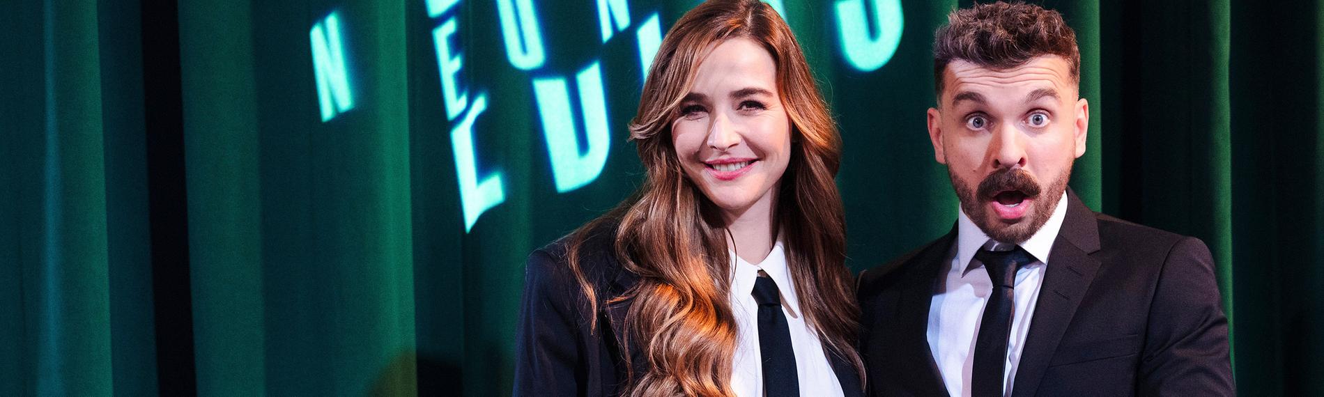 Moderator Edin Hasanovic posiert im Anzug in der Premiere seiner ZDFneo-Show "Edins Neo Night" mit der Moderatorin und Schauspielerin Katrin Bauerfeind, ebenfalls in einem eleganten Anzug.