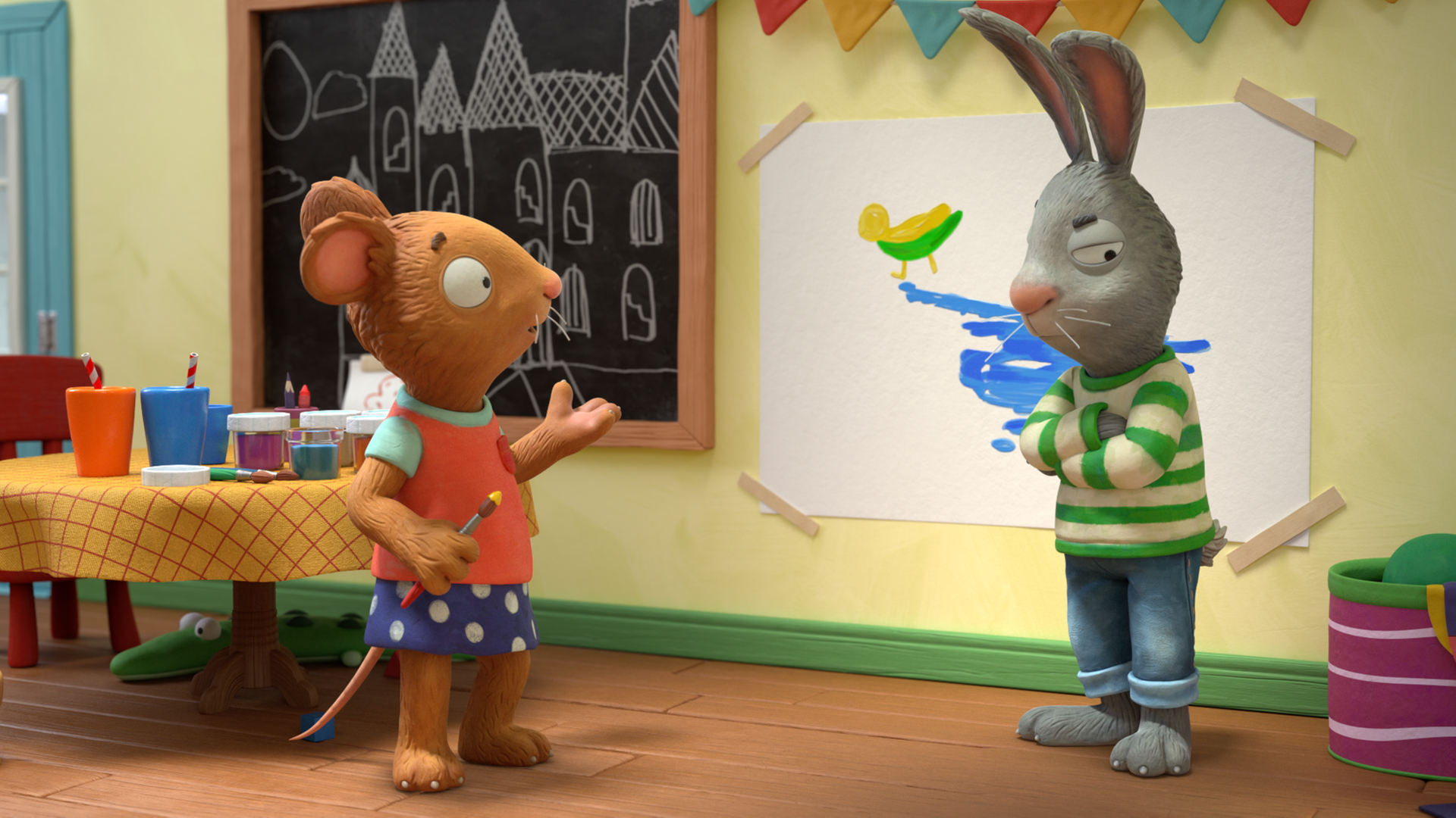 Posy (links) steht, mit einem Pinsel in der Hand, vor Pip (rechts) und spricht zu ihm. Pip steht vor dem Entebild mit blauer Farbe und verschränkt wütend seine Arme. Links im Hintergrund steht ein Tisch mit Pinseln und Wasserbechern.