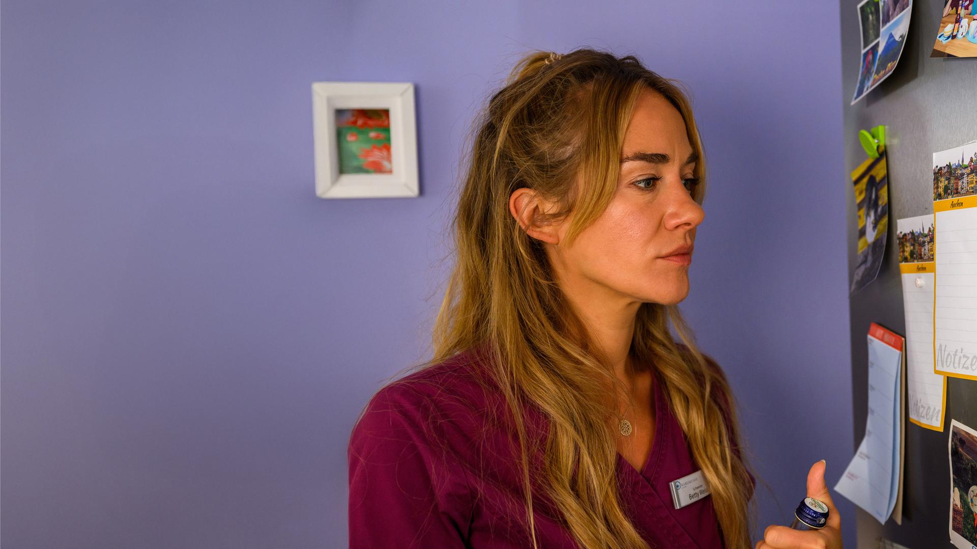 "Bettys Diagnose - Ein großer Schritt": Betty (Annina Hellenthal) steht vor der Pinnwand und schaut auf das Foto von Dr. Frank Stern.