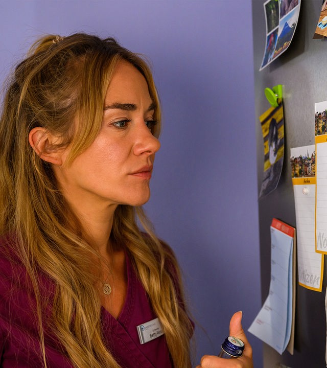 "Bettys Diagnose - Ein großer Schritt": Betty (Annina Hellenthal) steht vor der Pinnwand und schaut auf das Foto von Dr. Frank Stern.