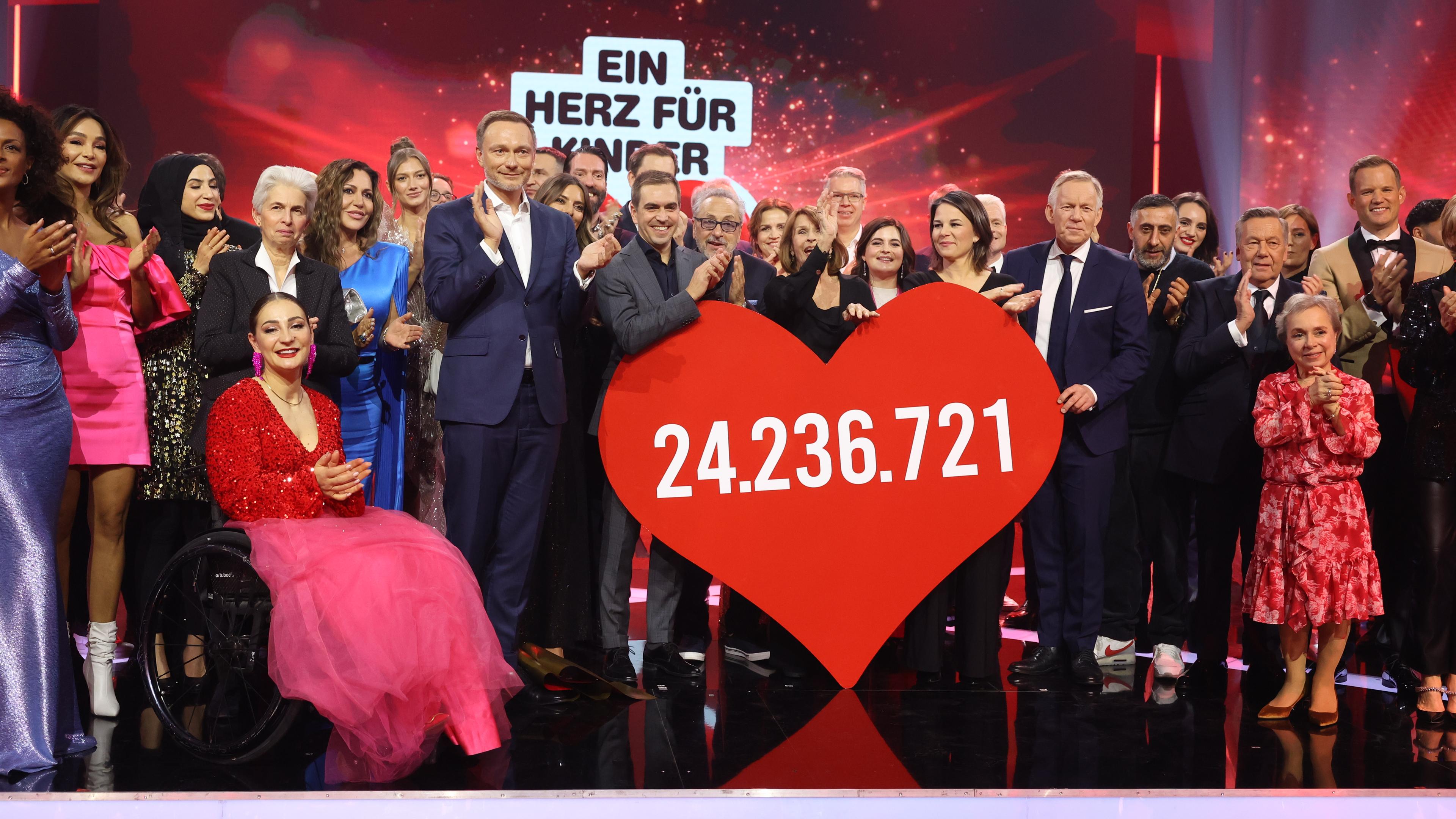 Gäste der Veranstaltung stehen auf der Bühne und halten ein Herz mit der gespendeten Geldsumme in Höhe von 24.236.721 Euro bei der "Bild"-Spendengala "Ein Herz für Kinder".