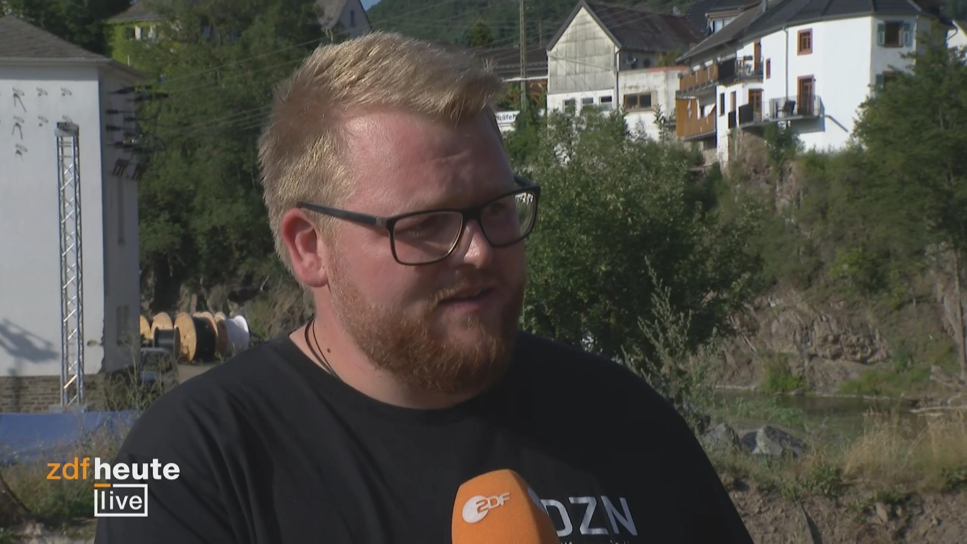 Links, Dennis Bradt von den Dachzeltnomaden spricht bei ZDFheute live über die Arbeit der freiwilligen Helfer nach der Flutkatastrophe vor einem Jahr.