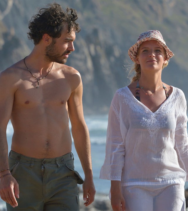"Ein Sommer an der Algarve": An der Meeresküste laufen Miguel Silva (Giovanni Funiati) und Julika Bergmann (Bea Brocks) nebeneinander her. Er schaut zu ihr und sie schaut nach vorne.