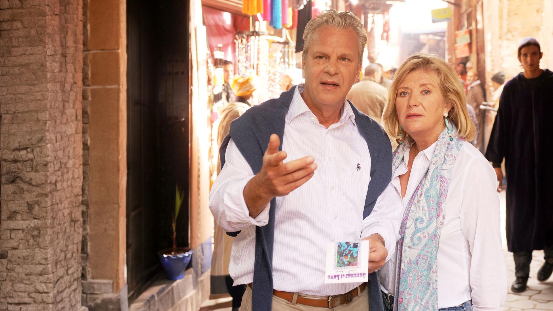 "Ein Sommer in Marrakesch": In einer engen Gasse in Marrakesch stehen Rudi (Peter Sattmann) und Tina (Jutta Speidel) eng nebeneinander und blicken rätselnd nach vorne.