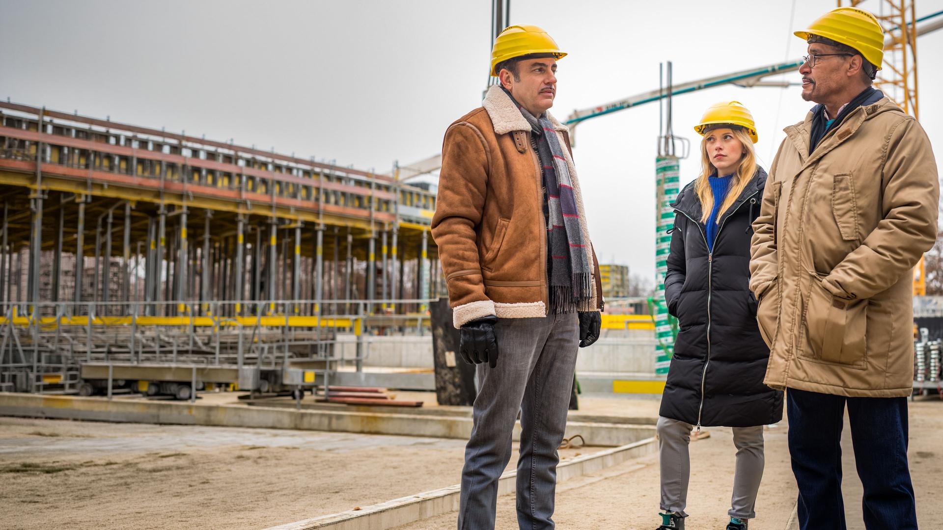 Franz Ainfachnur (Christofer v. Beau) und Resi Schwaiger (Mersiha Husagic) stehen mit Felix Schnell (Miguel Abrantes Ostrowski) auf der Baustelle.