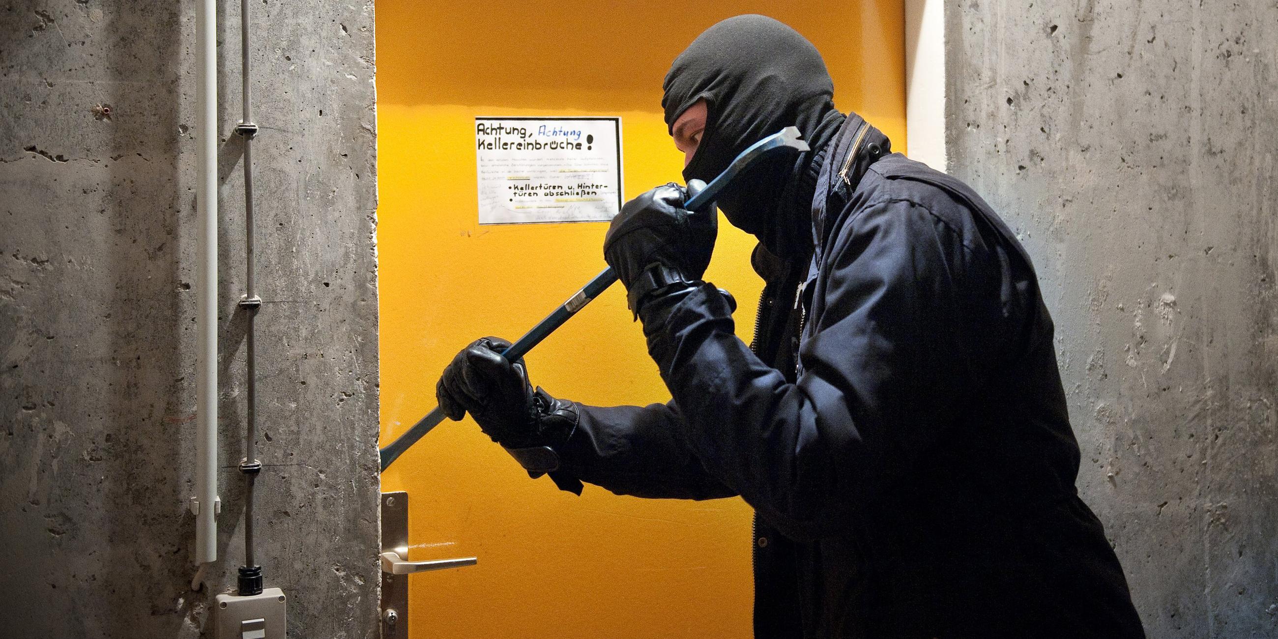 Ein Mann hebelt am Freitag (20.04.2012) in Berlin mit einem Brecheisen eine Tür auf