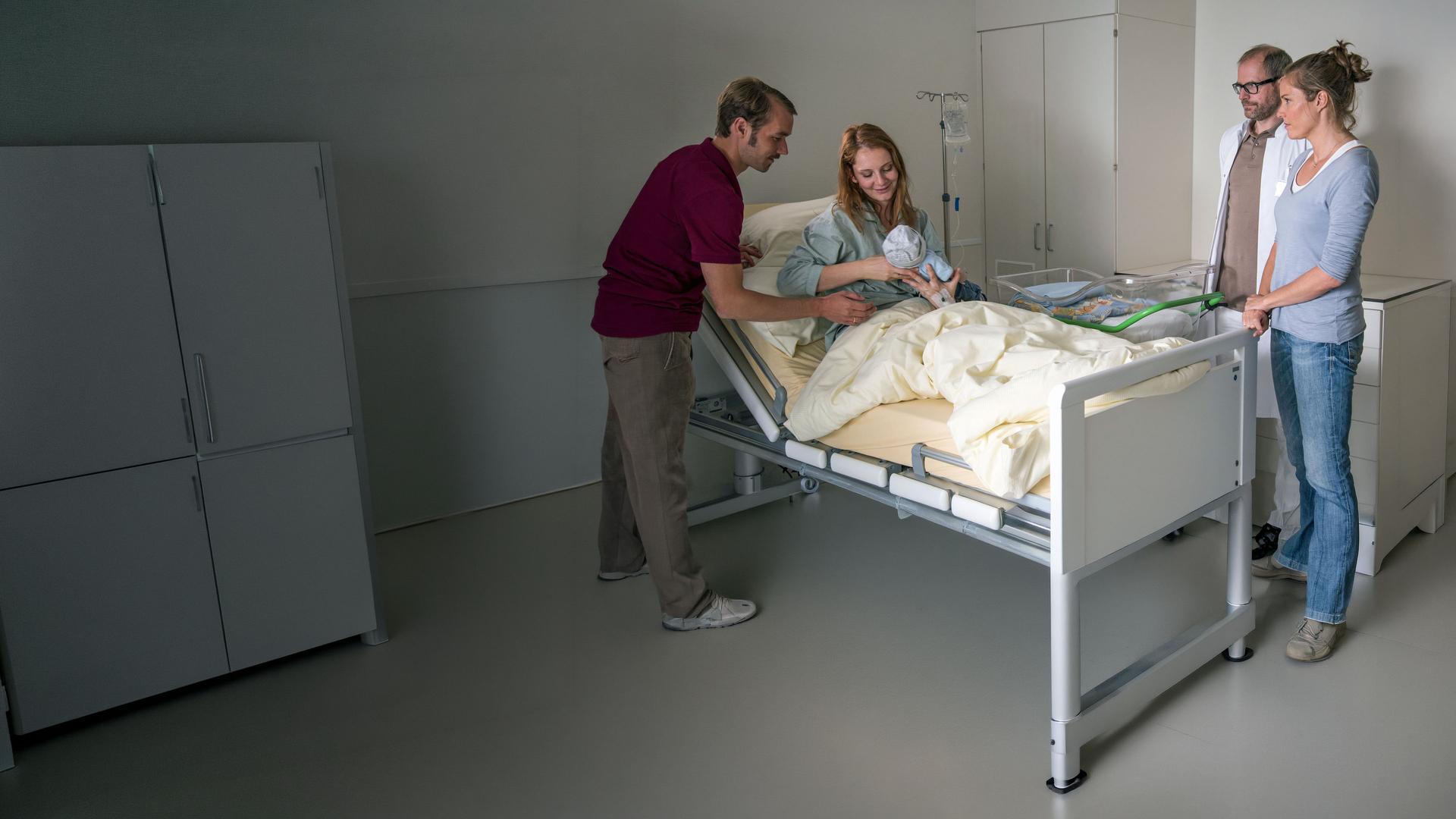 "Lena Lorenz - Eindeutig uneindeutig": In einem Krankenhauszimmer sitzt Nina Cramer (Daniela Schulz) mit einem Baby im Arm im Bett. Thomas Cramer (Max Woelky) beugt sich zu den beiden. An der anderen Seite des Bettes stehen Lena Lorenz (Patricia Aulitzky) und Dr. Keller (Thomas Limpinsel) und blicken auf die Familie.