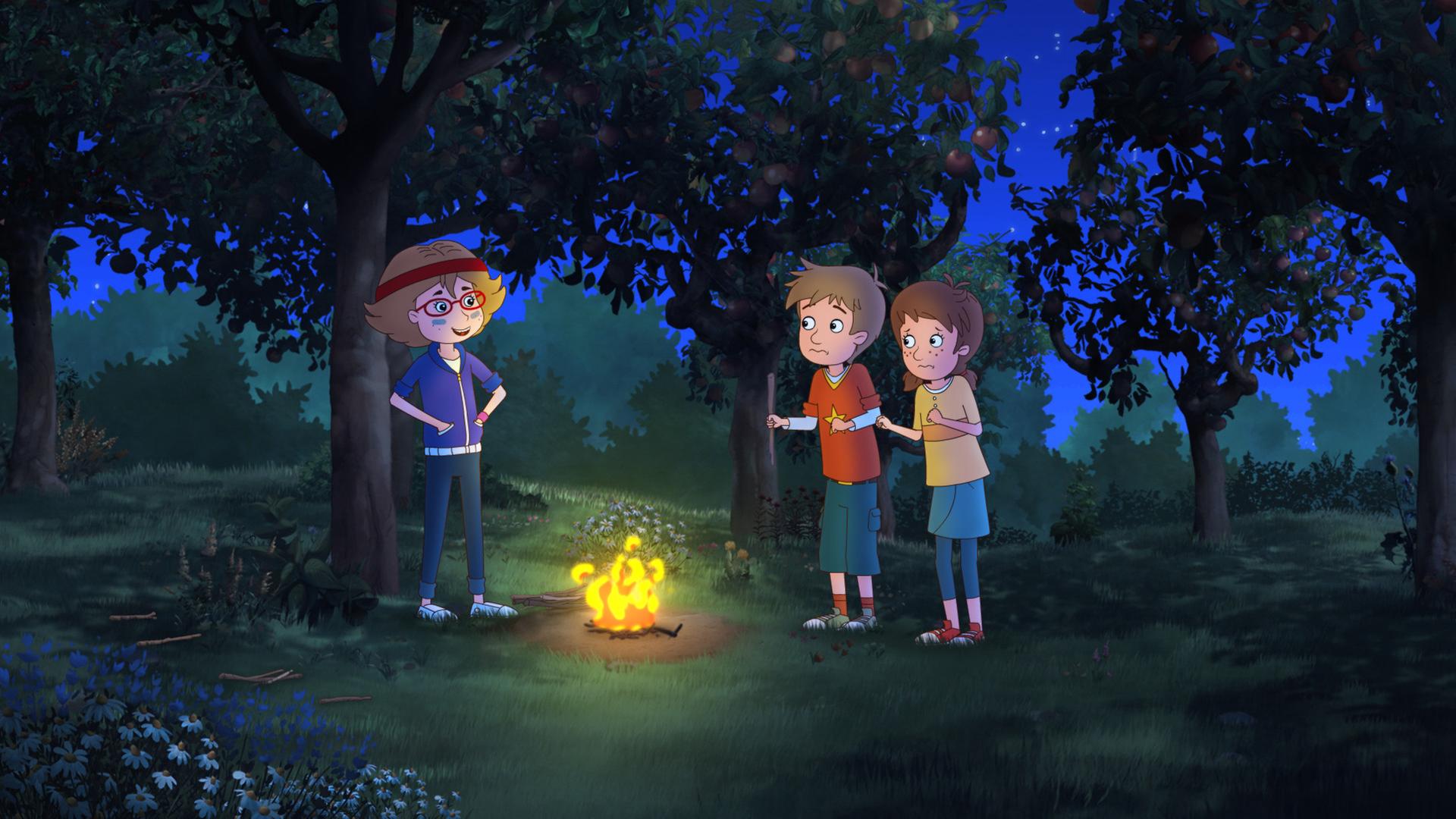 Malina (links) steht mit Lea und Luis (rechts) nachts am Lagerfeuer.