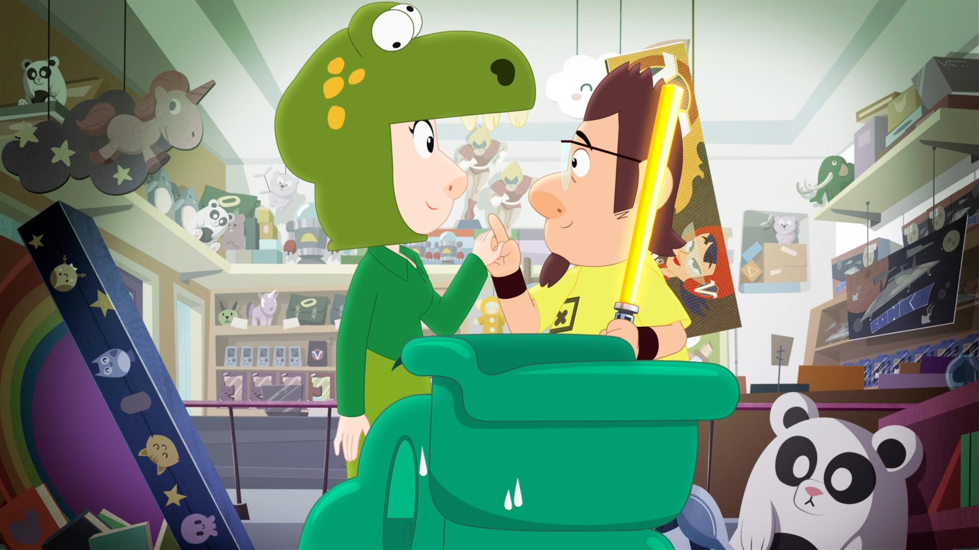 Kenny (rechts) und eine Frau im Dino-Kostüm (links) stehen sich in Kennys Spielzeugladen gegenüber und halten lächelnd Händchen.