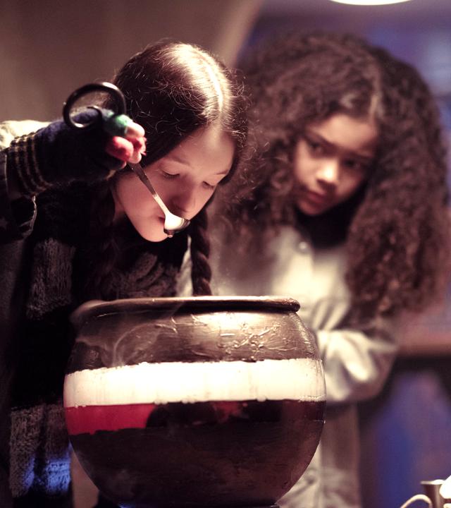 Mildred braut einen Weisheitstrank und trinkt ihn.