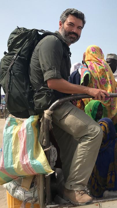 Reporter Reza Pakravan auf der Ladefläche eines Pick-up-Transporters, die er sich mit vielen Einheimischen teilt.