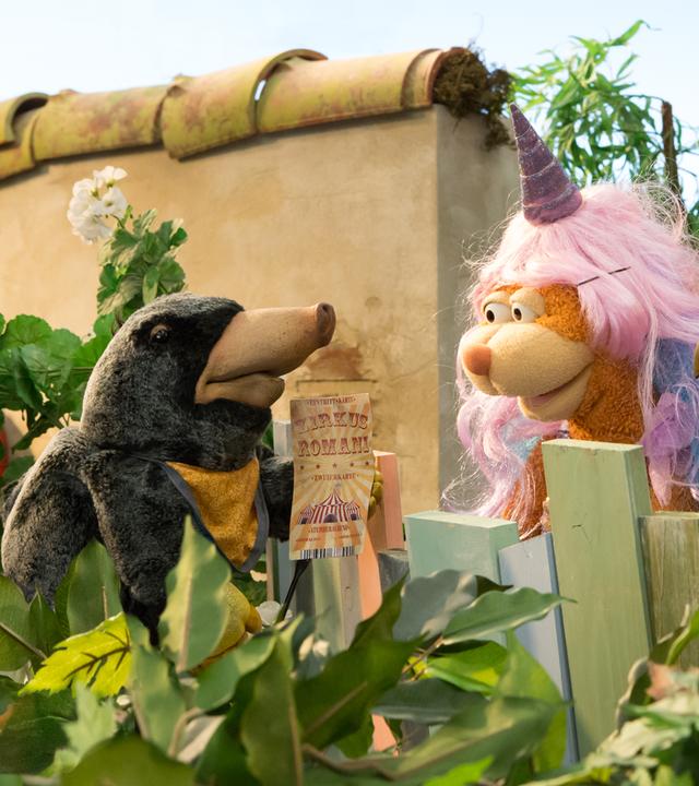 Maulwurfmädchen Grete zeigt Rudi und Ella eine Zirkuskarte.