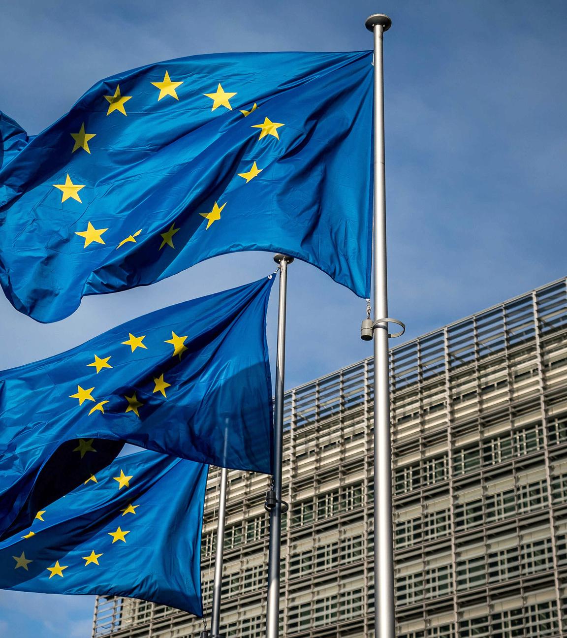 Drei Europaflaggen wehen vor dem Sitz der Europäischen Kommission.