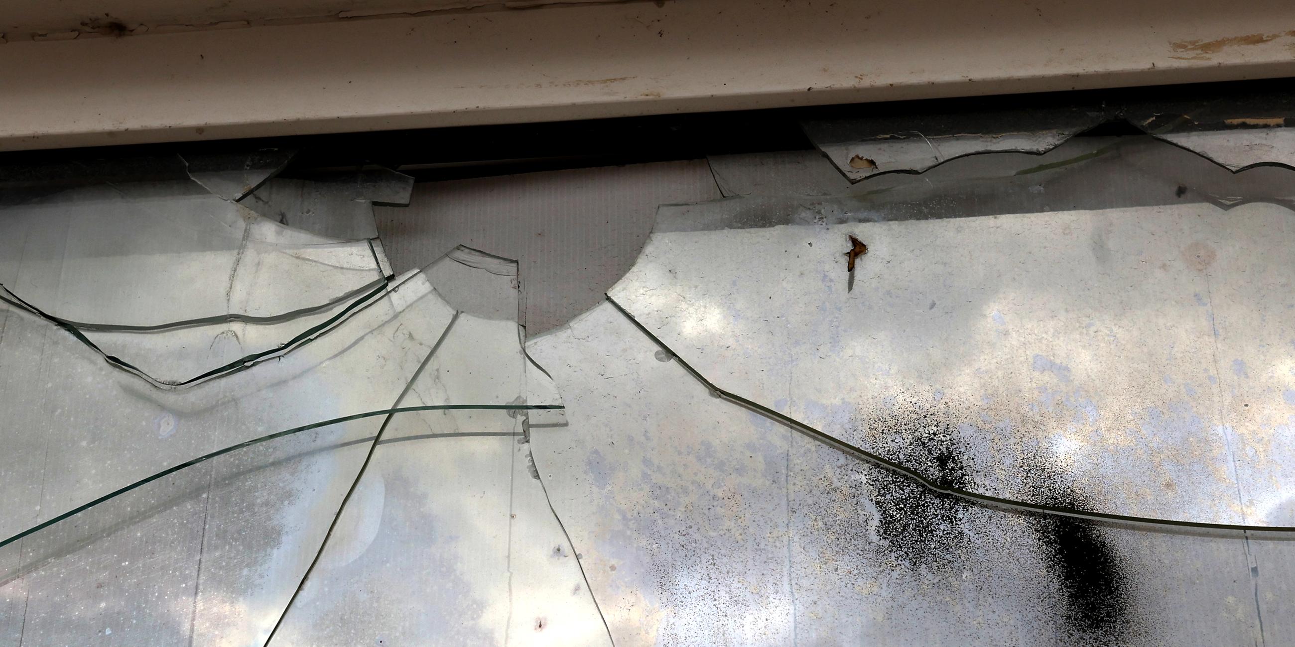 An einer beschädigten Fensterscheibe sind Einschüsse und Risse zu sehen