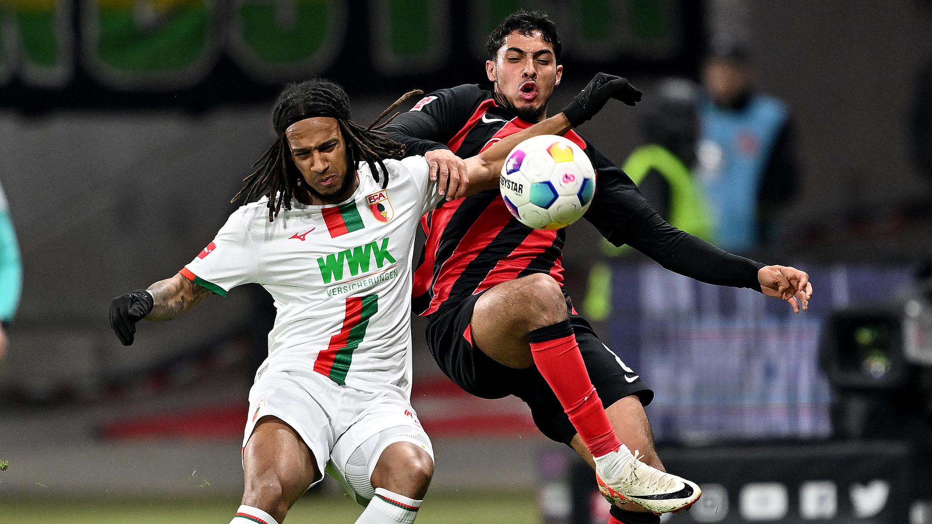 Augsburgs Kevin Mbabu (l) und Frankfurts Farès Chaibi kämpfen um den Ball.