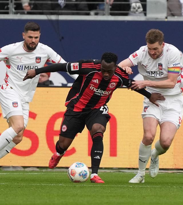 Arnaud Kalimuendo (Eintracht Frankfurt) wird gehalten von Patrick Mainka (1. FC Heidenheim) am 14.03.2026 in Frankfurt am Main. 