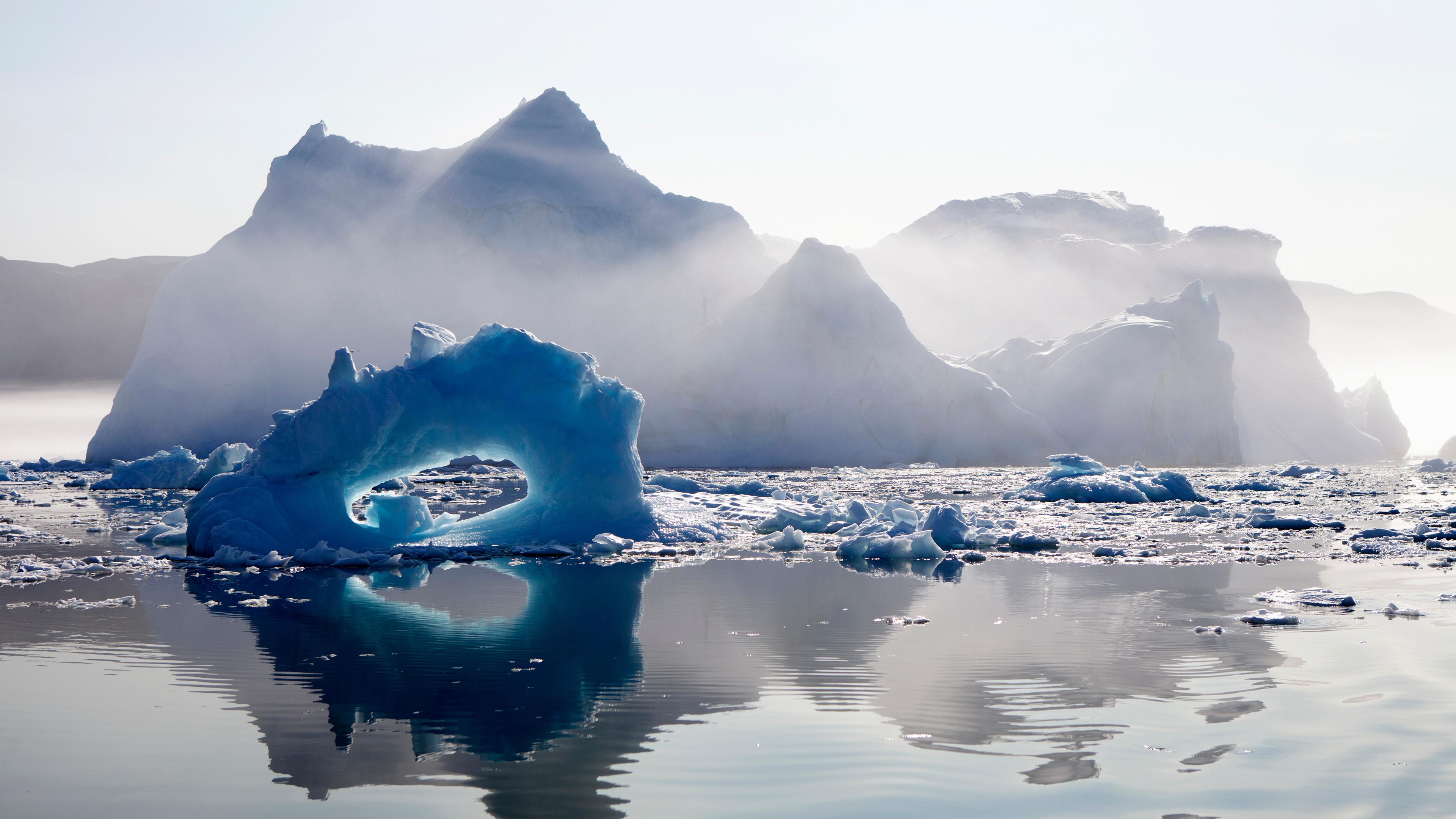 Im Sonnenlicht treibende Eisberge im Meer vor der Westküste Grönlands.