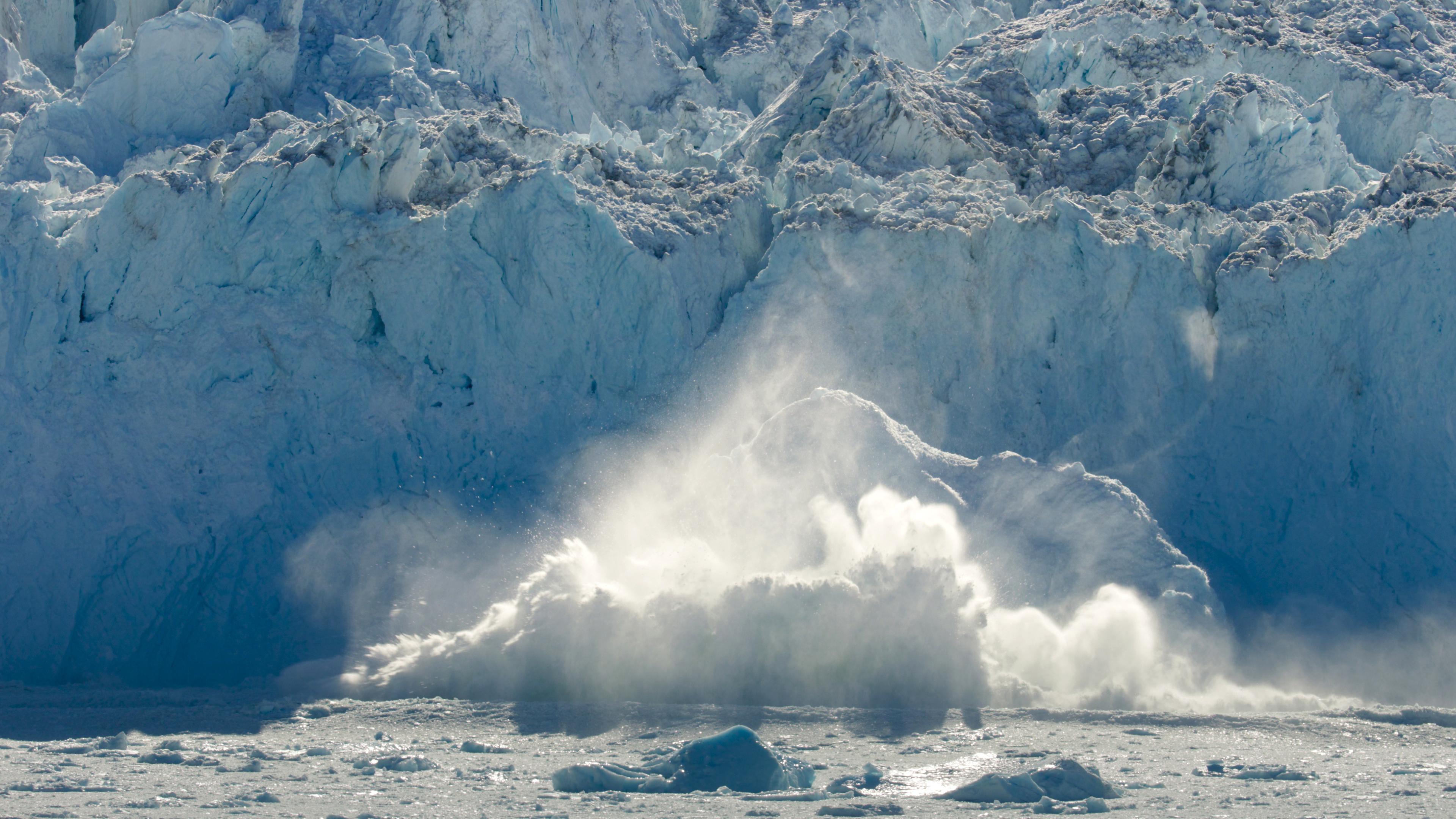 Eine große Eismasse bricht vom Grönländischen Eisschild in den Ozean.