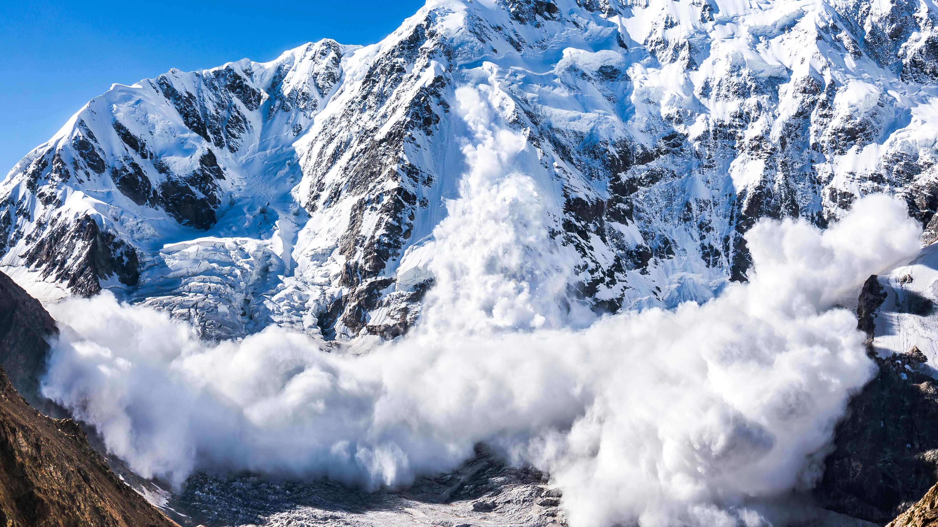 Eine mächtige Lawine bewegt sich einen Berghang am Schchara im Kaukasus hinab.