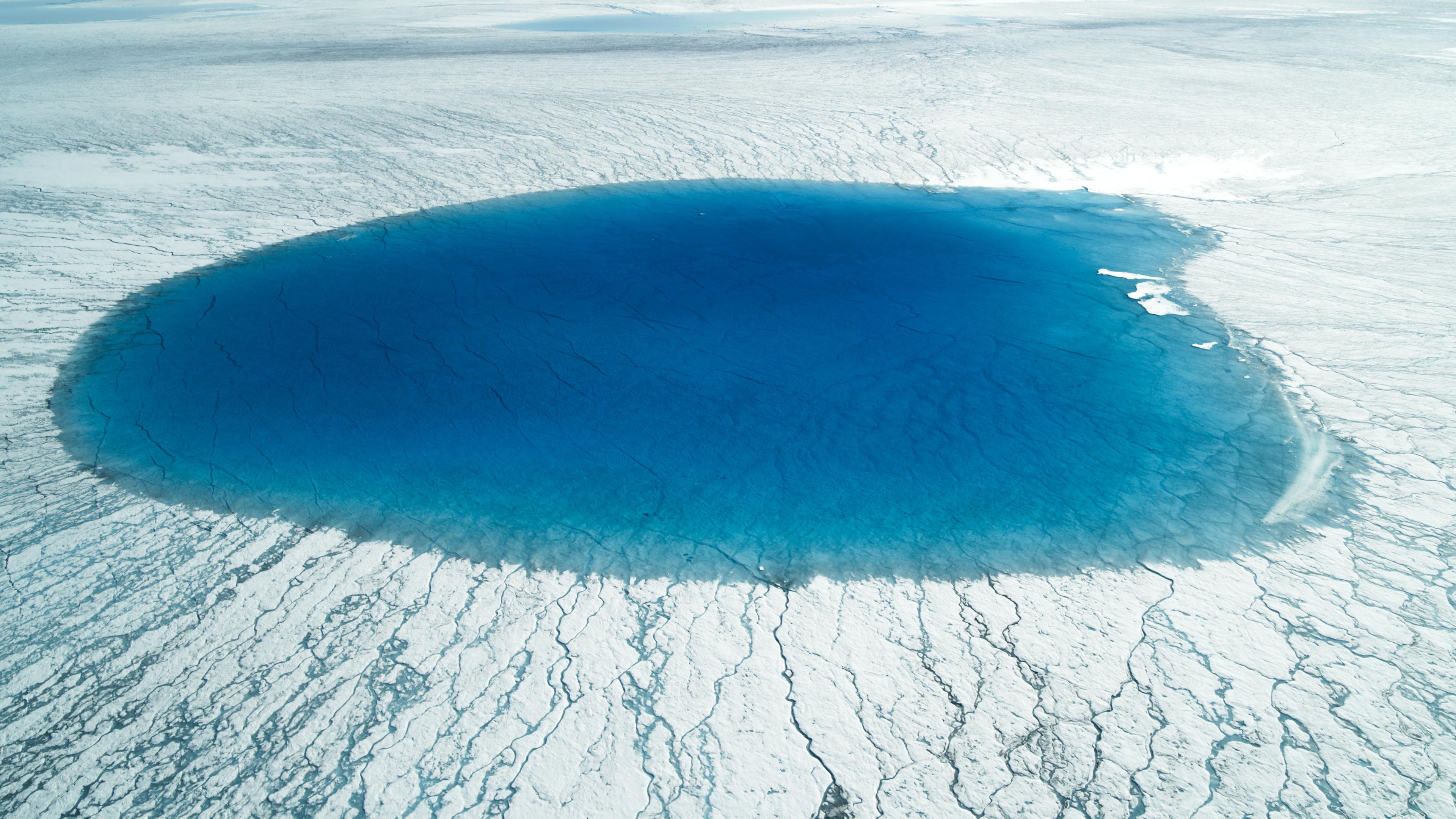 Luftaufnahme eines Schmelzsees inmitten des Eises.