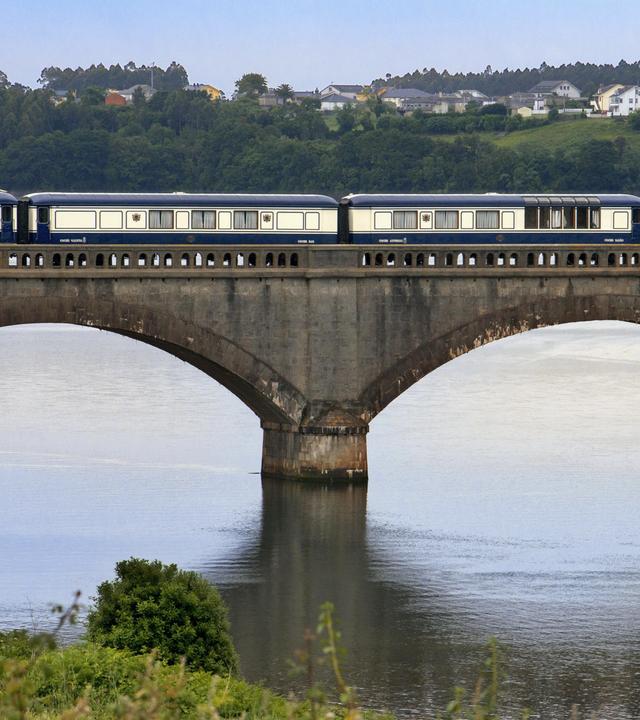 Ein Reisezug fährt über einen Fluss