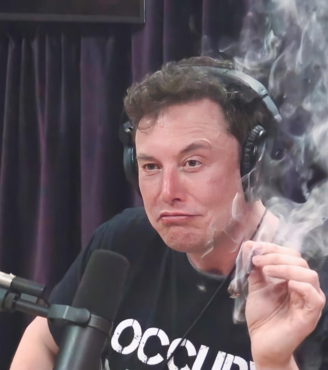 Elon Musk, mit schwarzem T-Shirt mit weißer Aufschrift, sitzt während eines Interviews im Jahr 2018 vor einem Mikrophon und hält in der linken Hand einen Joint, der qualmt.