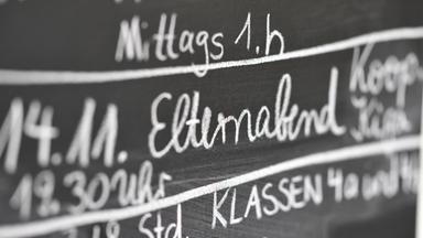 Auf einer Tafel steht "Elternabend".
