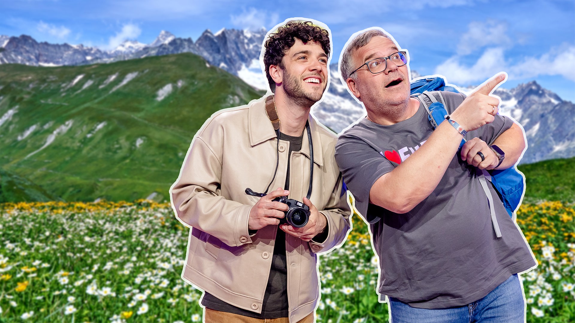Vor einer alpinen Kulisse mit Wiesen und Bergen schauen Luca Hänni und Elton nach oben. Elton deutet mit dem Finger auf etwas in der Ferne.