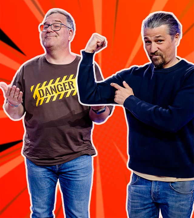 Vor einem bunten, comicartigen Hintergrund hebt Elton die Hände. Tommy Scheel posiert daneben und spannt seinen Arm an.
