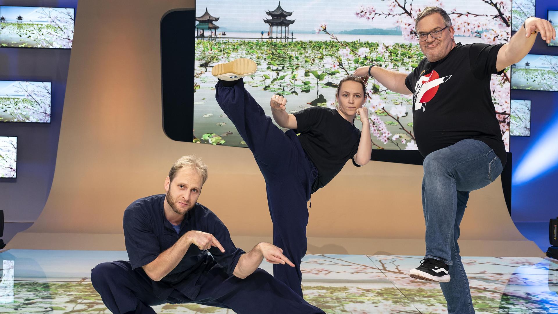 Kung-Fu-Meister Arno Wünsch, Kung-Fu-Trainerin Marina Berljafa und Elton stehen im Studio und präsentieren Posen aus verschiedenen Kung-Fu-Stilen.