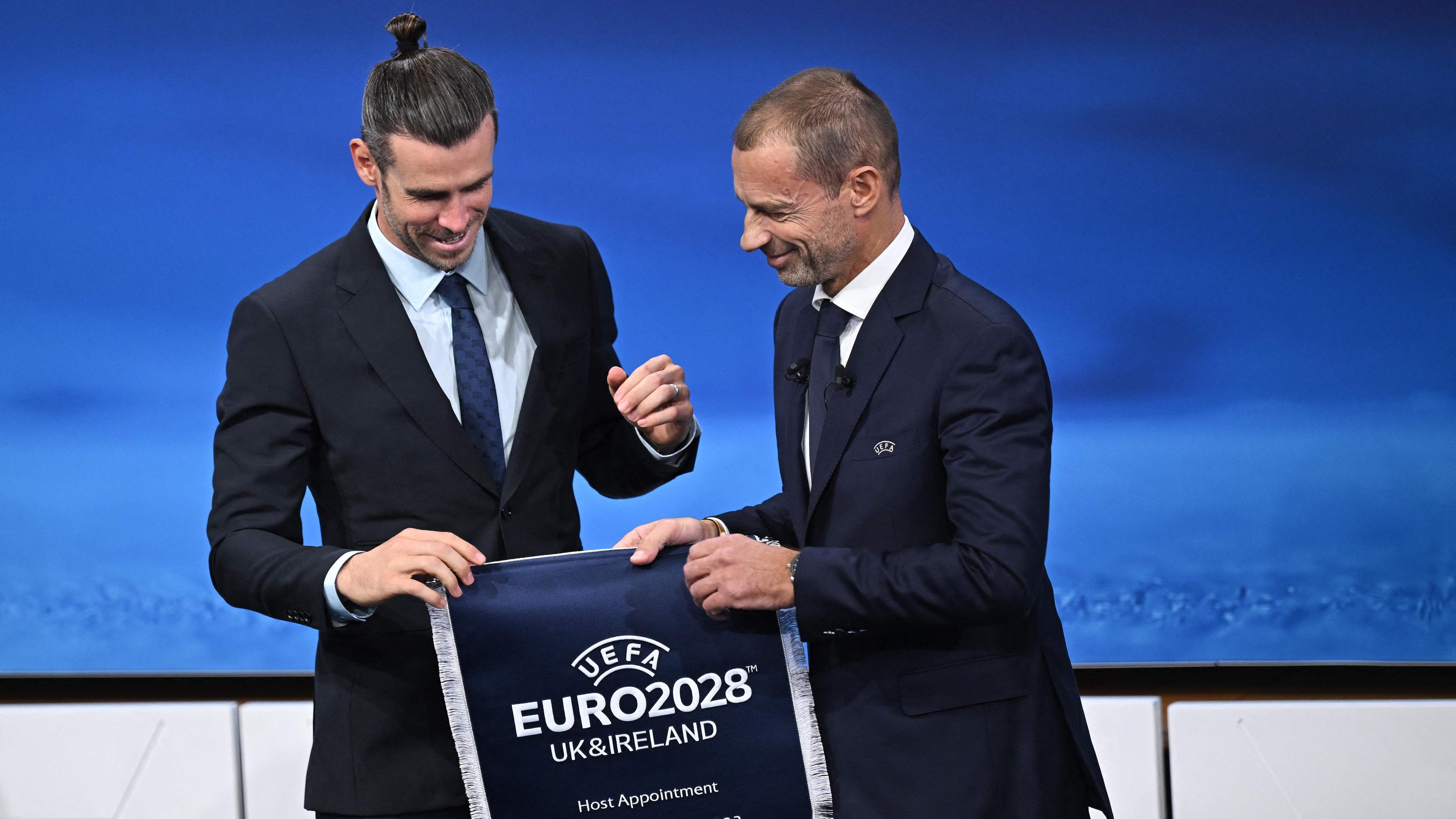 UEFA-Präsident Aleksander Ceferin (r.) gratuliert Gareth Bale, einem Botschafter der EM 2028.