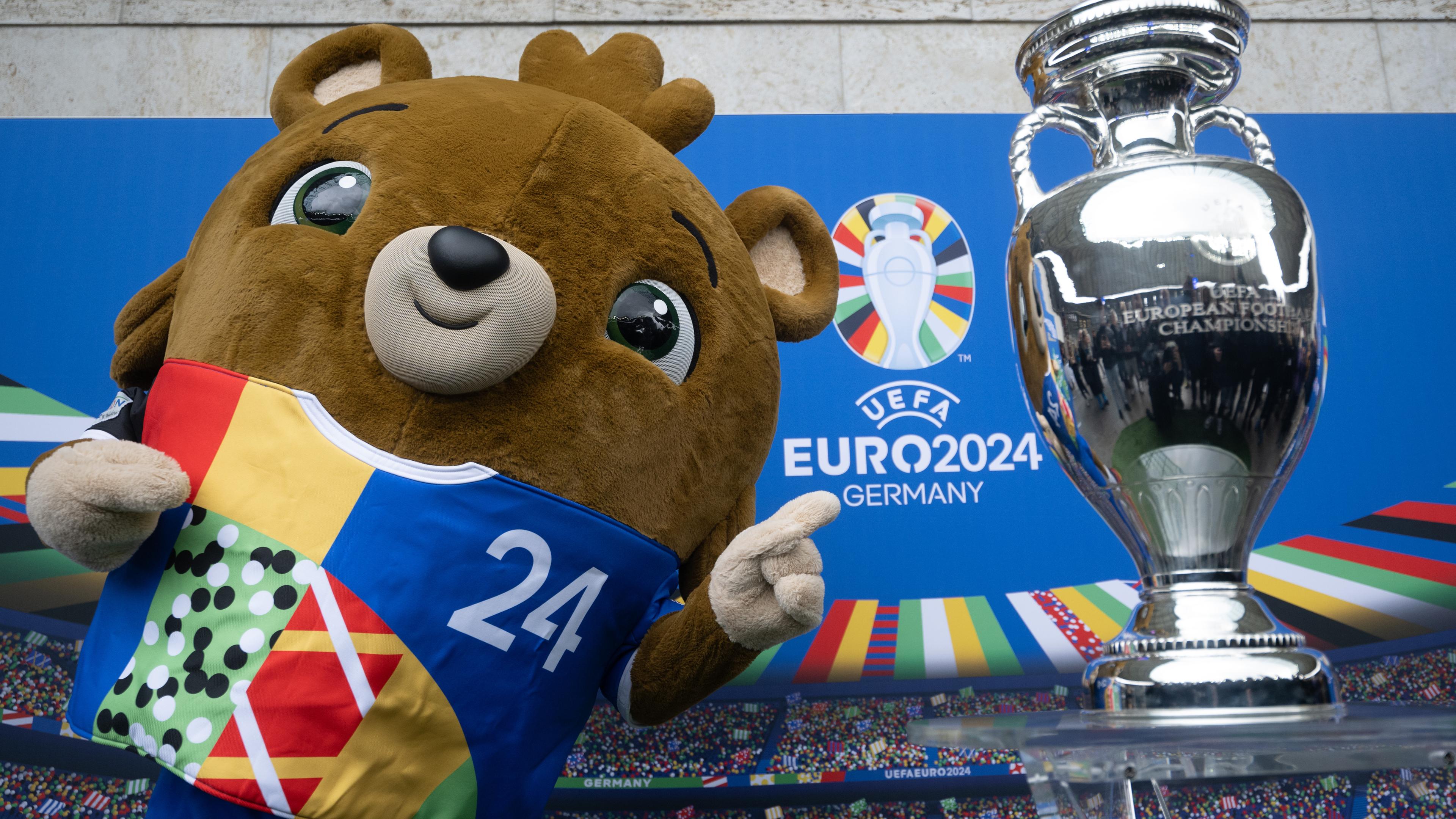 24.04.2024: Das Maskottchen Albärt steht während der Präsentation des EM-Pokals im Berliner Olympiastadion neben dem Pokal.