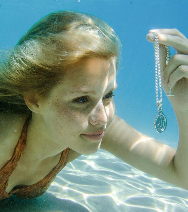 Meerjungfrau Emma findet im Meer eine Kette mit Anhänger.