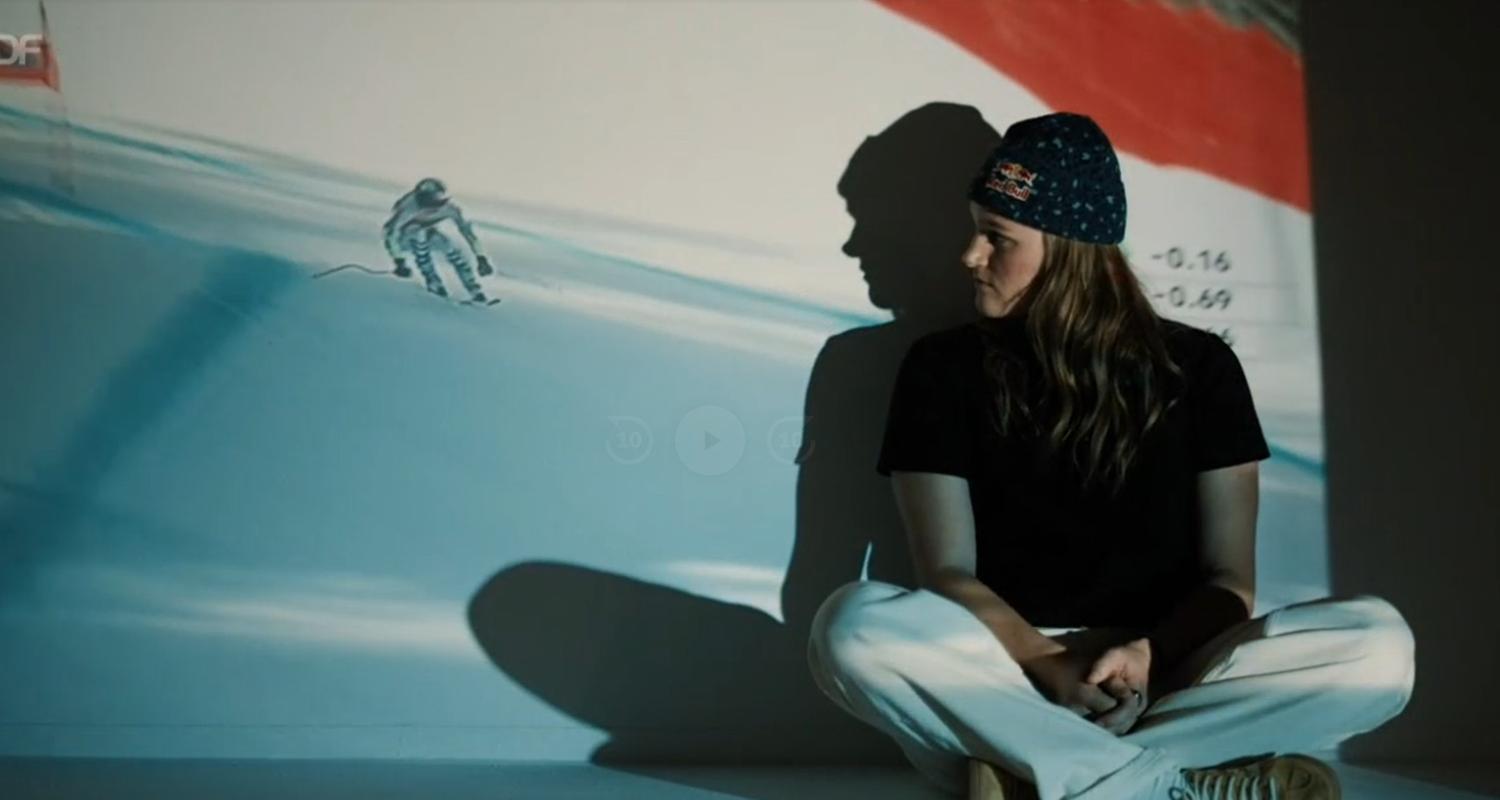 Skirennläuferin Emma Aicher blickt auf ein Rennbild von ihr.