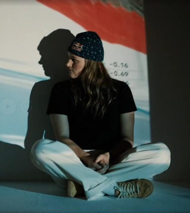 Skirennläuferin Emma Aicher blickt auf ein Rennbild von ihr.